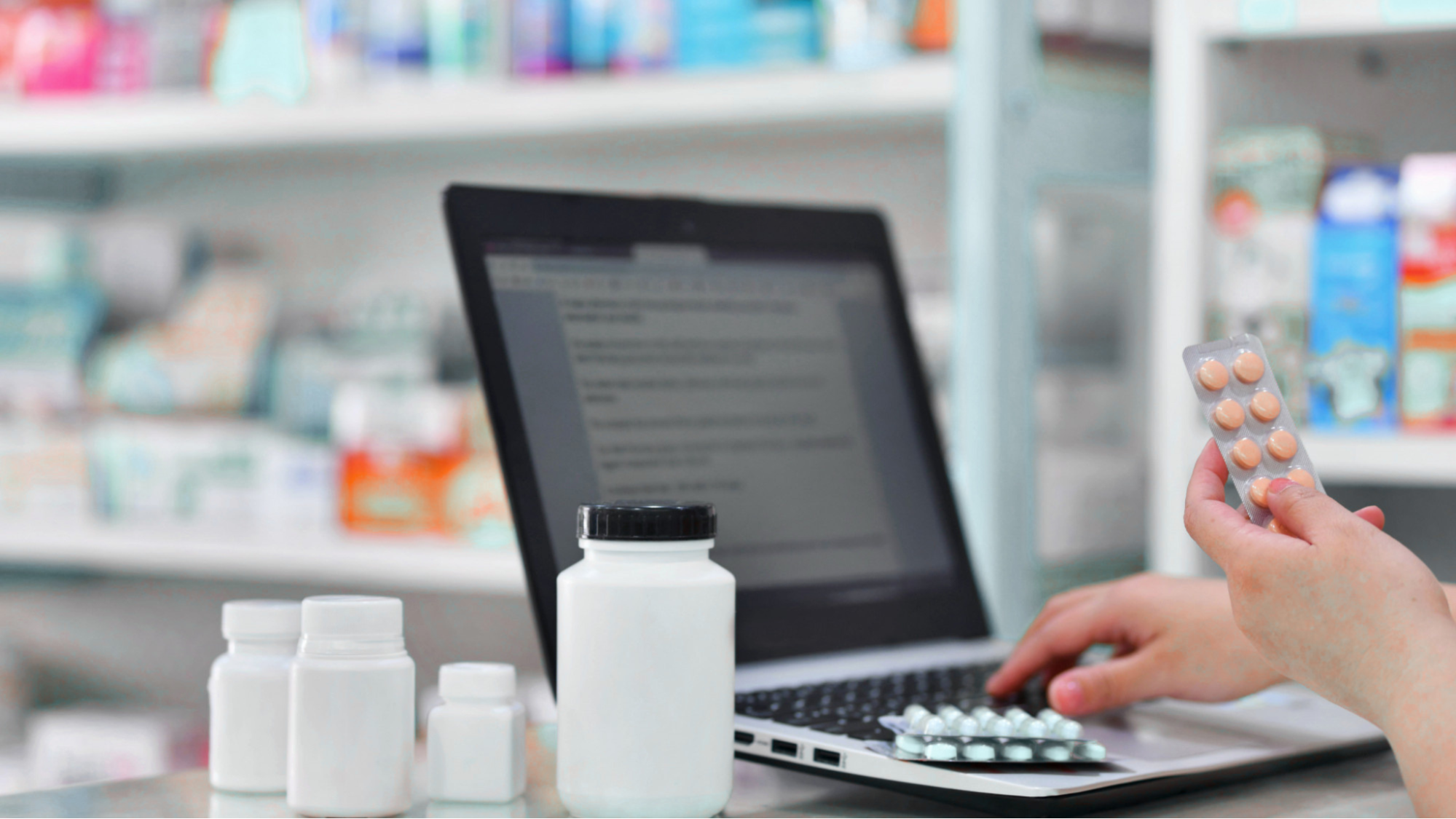 Pharmacist using digital management software to organize pharmacy delivery and prescription tracking.